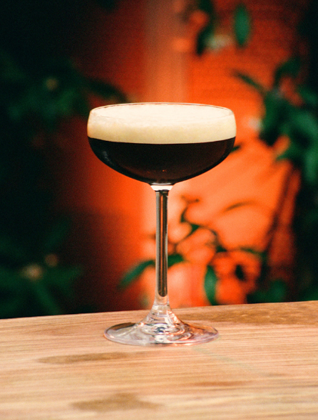 Cocktail matcha latte du bar Indie Beach Pampelonne servi sur comptoir pierre au soleil