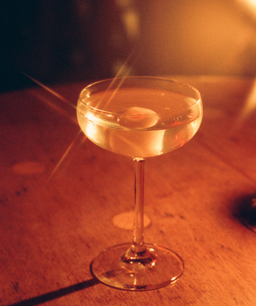 Cocktail rouge à la pastèque dans un verre taillé sur table ronde, paille en bambou – bar La Sauvageonne, Ramatuelle