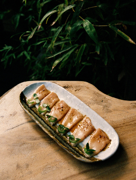Bol de crevettes saut&eacute;es en bouillon vert pos&eacute; sur table en bois, lumi&egrave;re naturelle rasante &ndash; restaurant La Sauvageonne, Ramatuelle