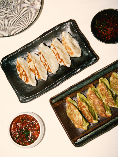 Vue du dessus de quatre plats asiatiques sur table en bois : bao vapeur, tartare sur pierre, maki sur pr&eacute;sentoir &eacute;toile et dessert matcha &ndash; restaurant La Sauvageonne, Ramatuelle