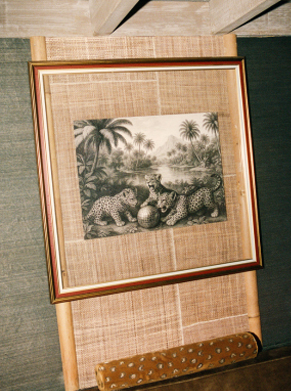 Table ronde dress&eacute;e avec lampe tress&eacute;e et banquette velours moutarde, grande lampe &agrave; franges au premier plan &ndash; restaurant La Sauvageonne, Ramatuelle
